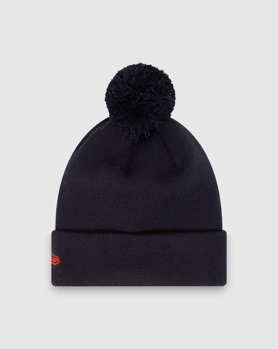 Navy knit beanie with a fluffy pom and folded cuff featuring Oracle Red Bull patch and New Era insignia