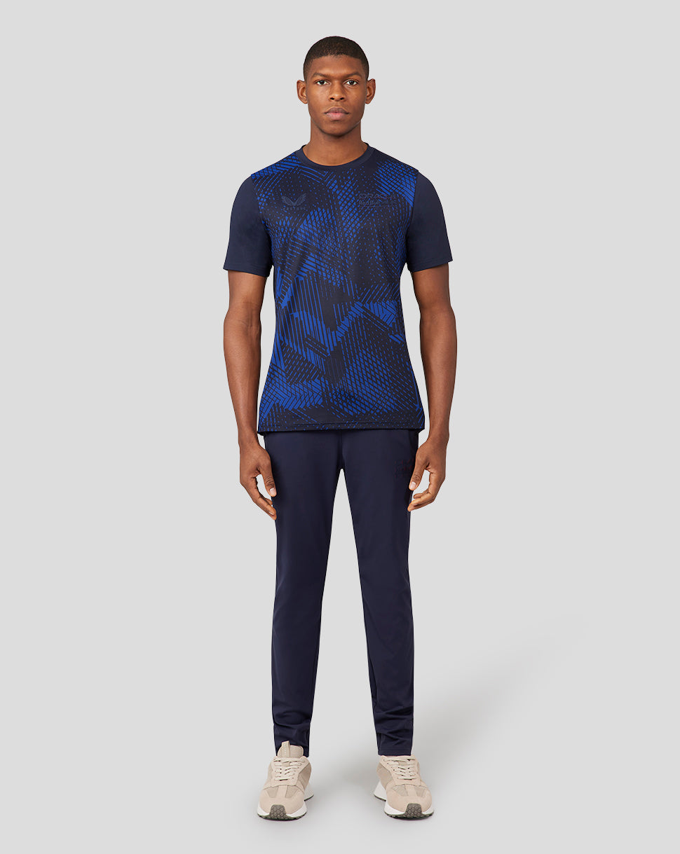 Full body shot of male model in Oracle Red Bull Racing Night Sky performance running T-shirt with geometric blue pattern.