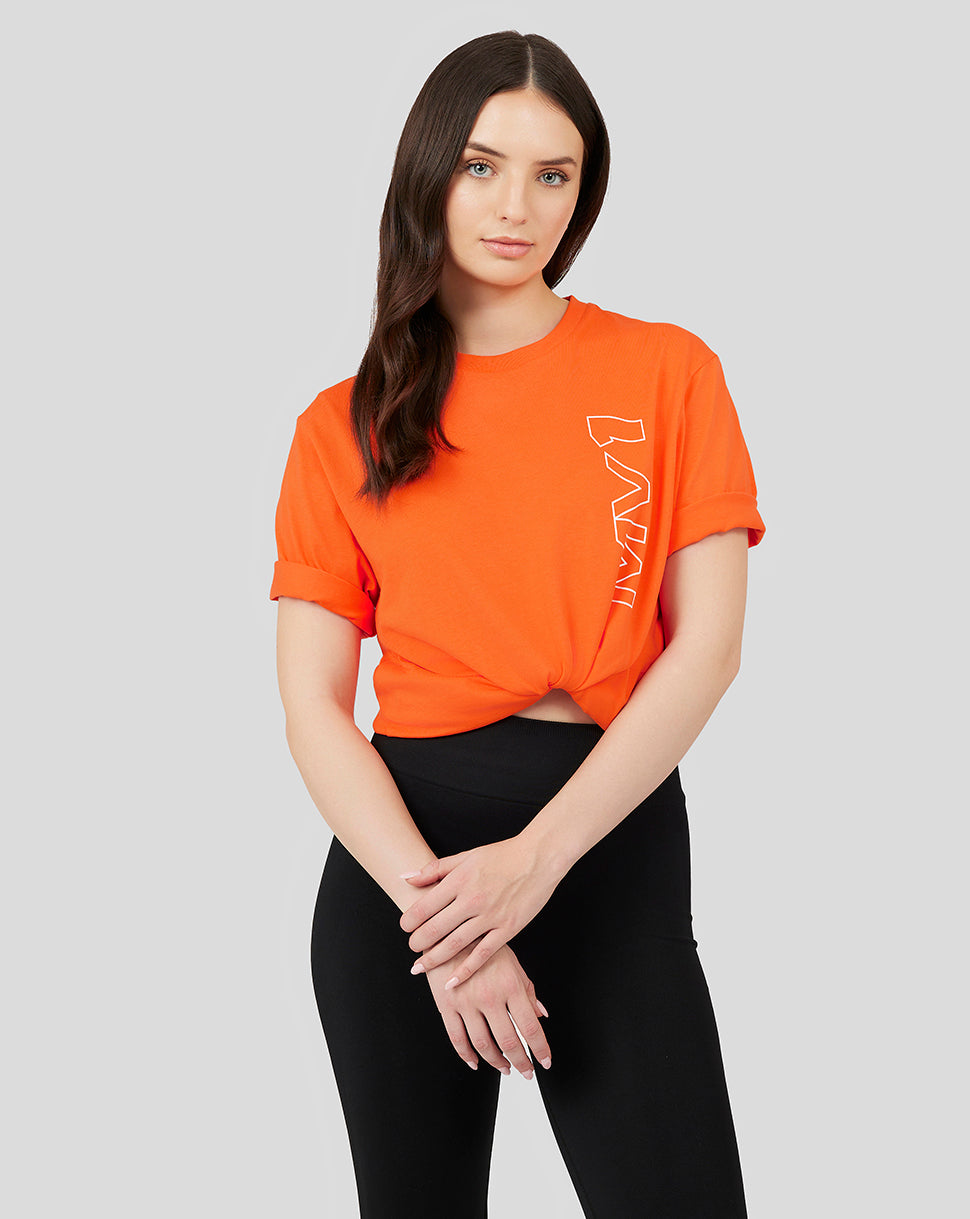 Model wearing bright orange Oracle Red Bull Racing Core Driver T shirt tied at the waist with logos on the back of the neck sleeve and chest