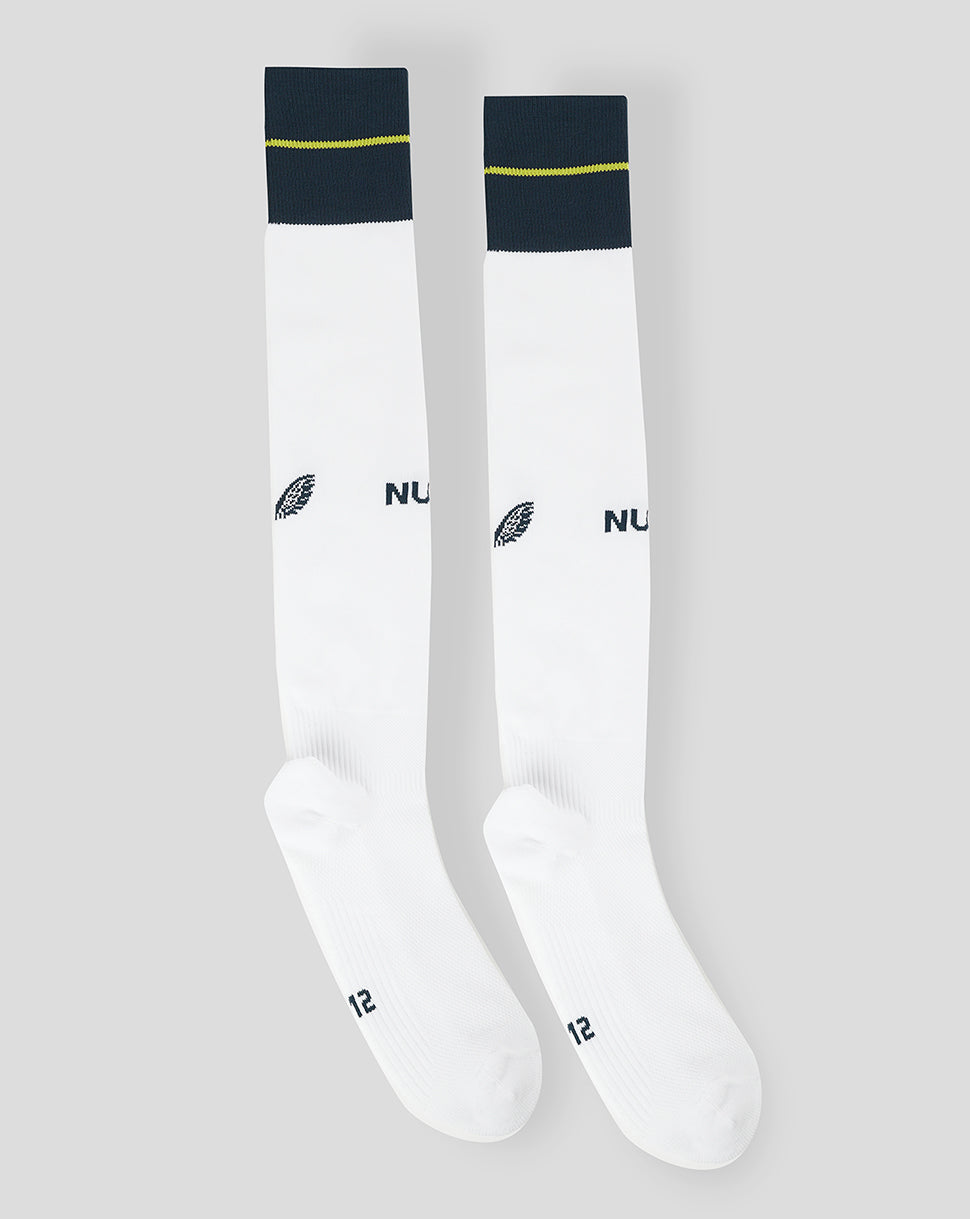 Pair of white Newcastle United Junior 23/24 Home Alternate Socks with navy cuffs and lime stripe reinforced heel and footbed, Castore branding on calf and NUFC branding on shin