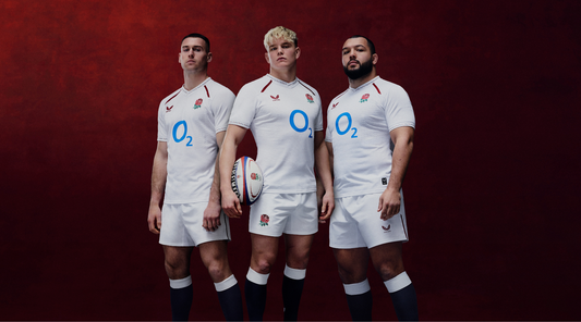 Three rugby players in white jerseys with rose crest and O2 logo stand together against a dark red background