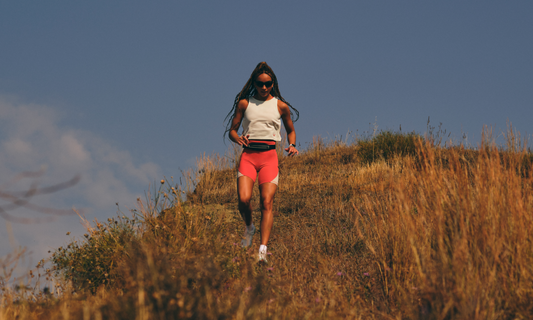 Female runner on a sunlit hilltop illustrating endurance training benefits