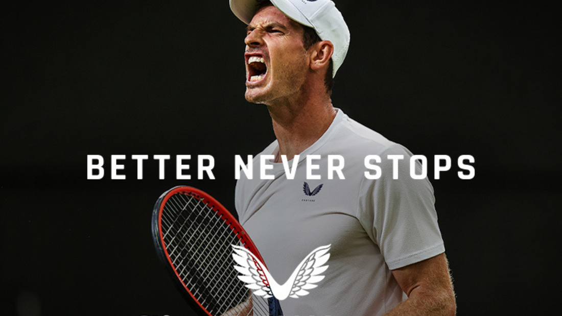 Tennis player in a white cap and white shirt shouting while gripping a red racket against a dark background.