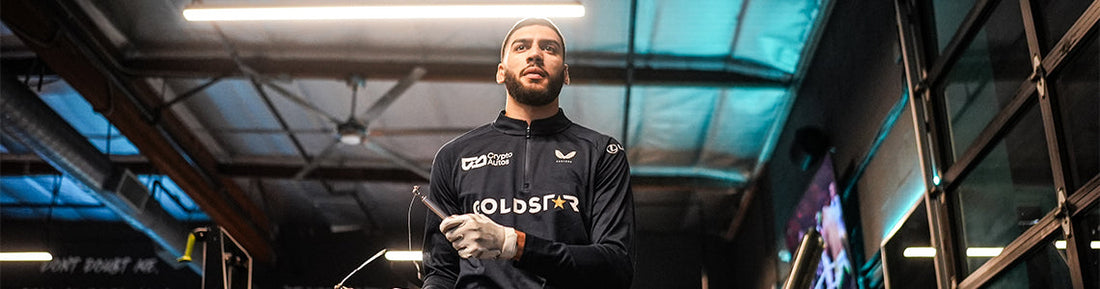 Male boxer in a gym wearing a branded training top preparing for a boxing workout