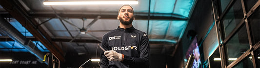 Male boxer in a gym wearing a branded training top preparing for a boxing workout