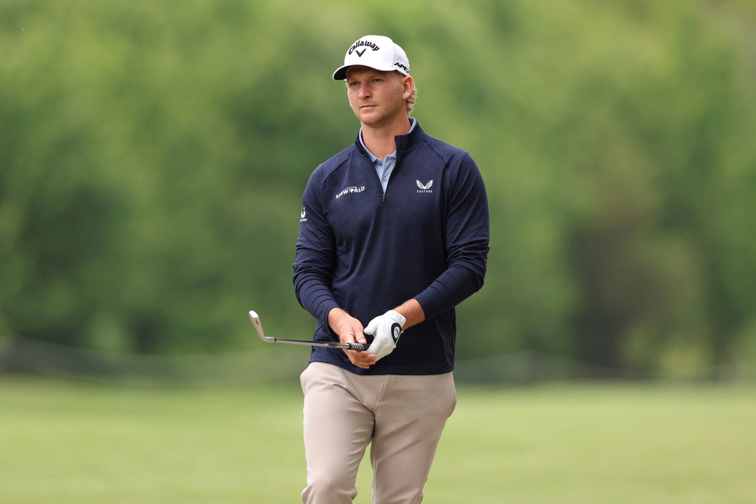 German professional golfer wearing a navy Castore polo and holding a golf club on a green course