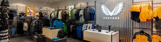 Castore store interior in Rotterdam with clothing racks and a bright logo wall