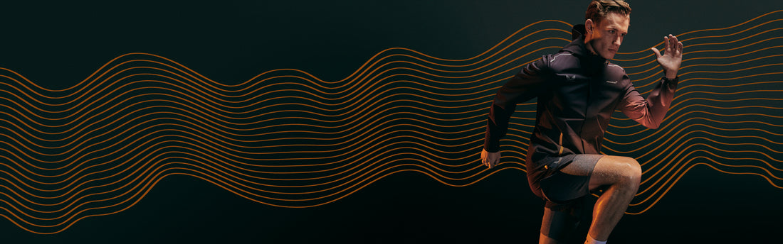 Athlete in a McLaren Castore performance jacket runs forward against a dark background with orange wave lines