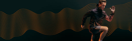Athlete in a McLaren Castore performance jacket runs forward against a dark background with orange wave lines