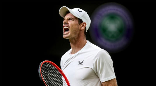 Male tennis player in white cap and shirt shouts in celebration gripping a red tennis racket