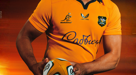 Rugby player in an orange Wallabies jersey holding a rugby ball
