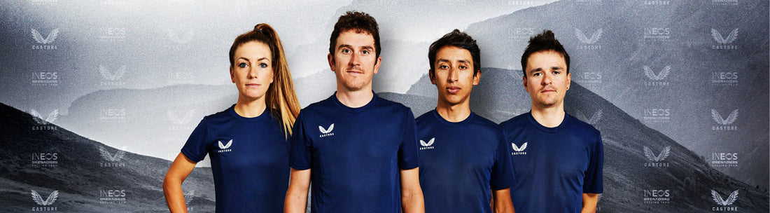 Group of four Castore athletes in navy shirts posing against a gray backdrop with INEOS Grenadiers branding