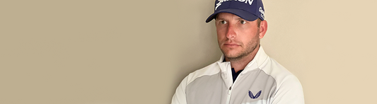 Dean Burmester in Castore golf apparel wearing a white jacket and navy cap