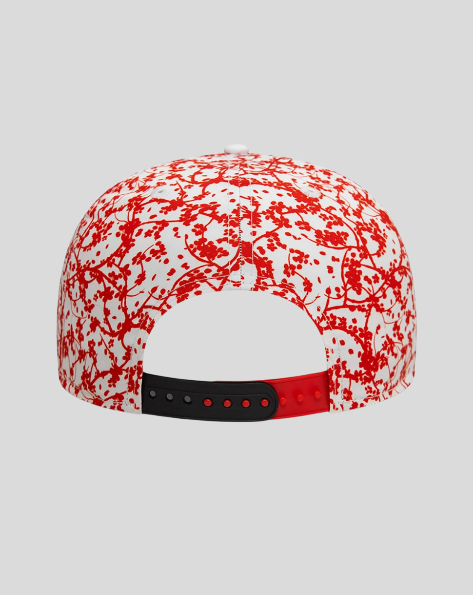 Back view of white Red Bull Racing cap with blossom pattern across the crown and a two tone adjustable strap in black and red