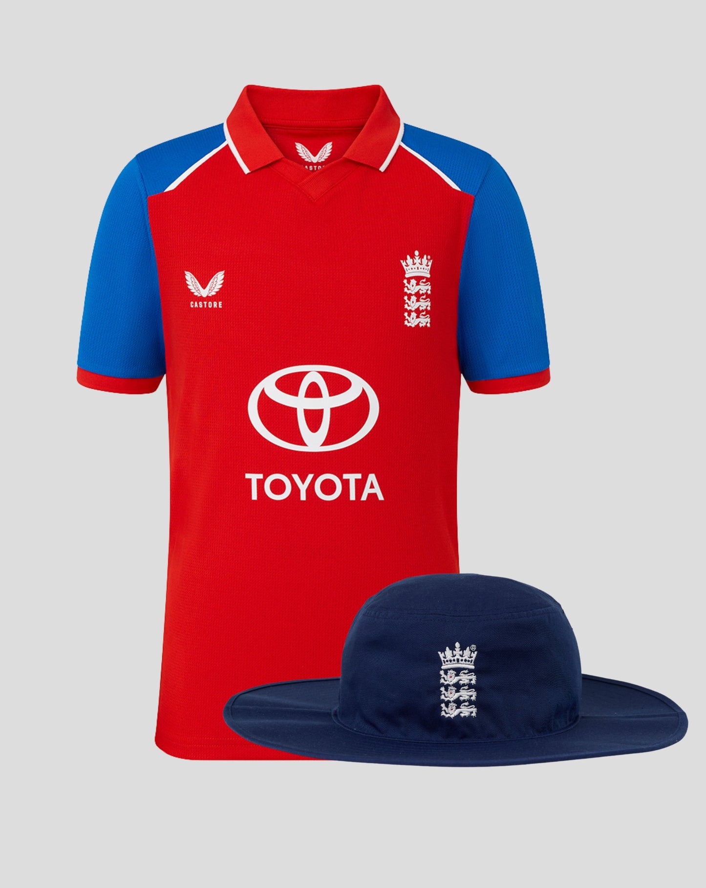 Junior England 26/27 T20 shirt in red with blue sleeves and a navy brim hat featuring the Three Lions crest and Toyota logo
