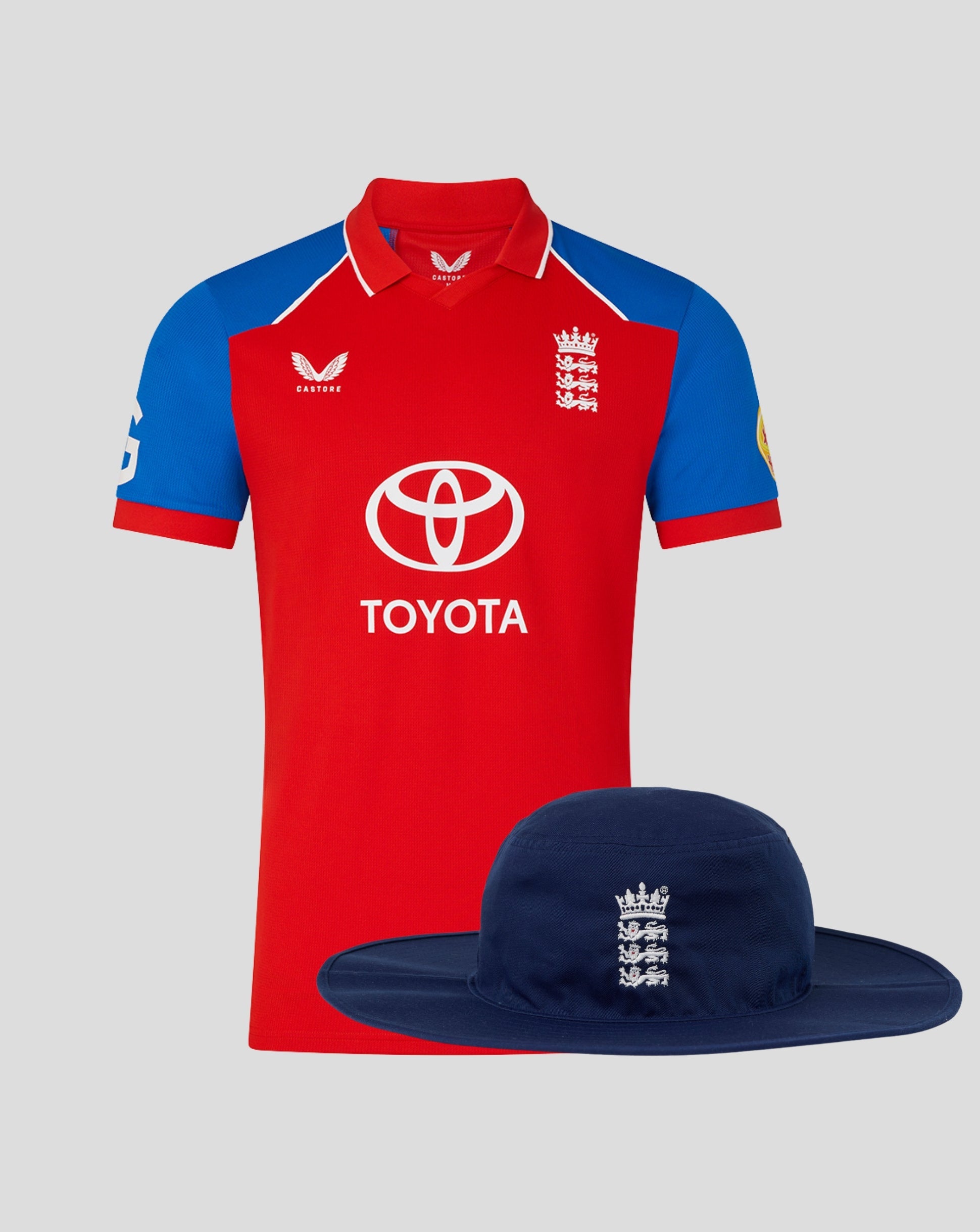 England 26/27 T20 shirt in red with blue sleeves shown with a navy brim hat featuring the Three Lions crest