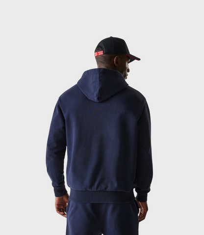 Rear view of a person in a navy hoodie with hood down showing the relaxed fit and ribbed hem