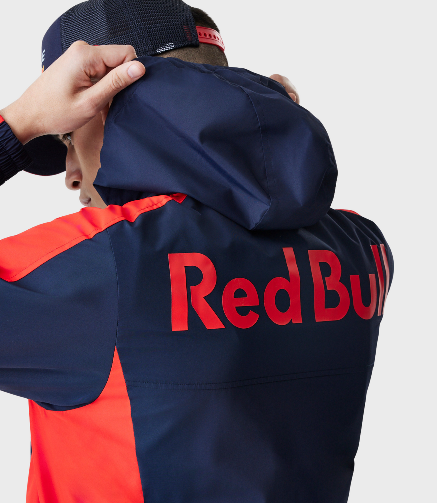 Close up of navy jacket with large Red Bull lettering across chest and red shoulder stripe.