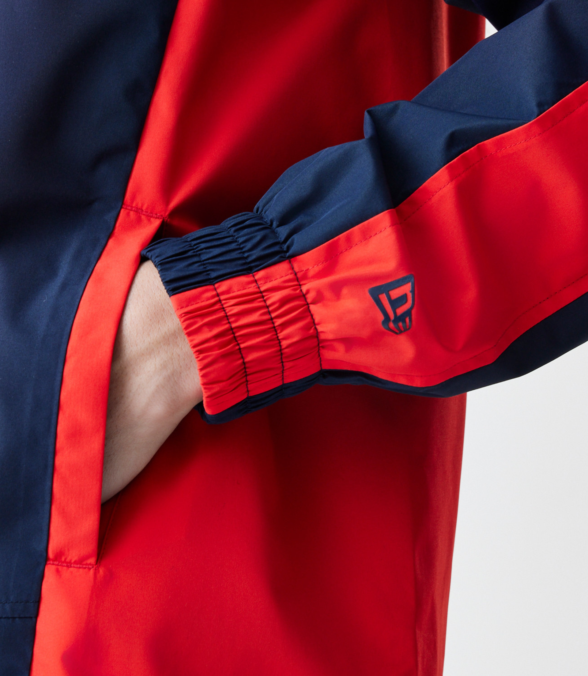 Rear view of navy Red Bull Racing Windrunner jacket with bold Red Bull wordmark on back.