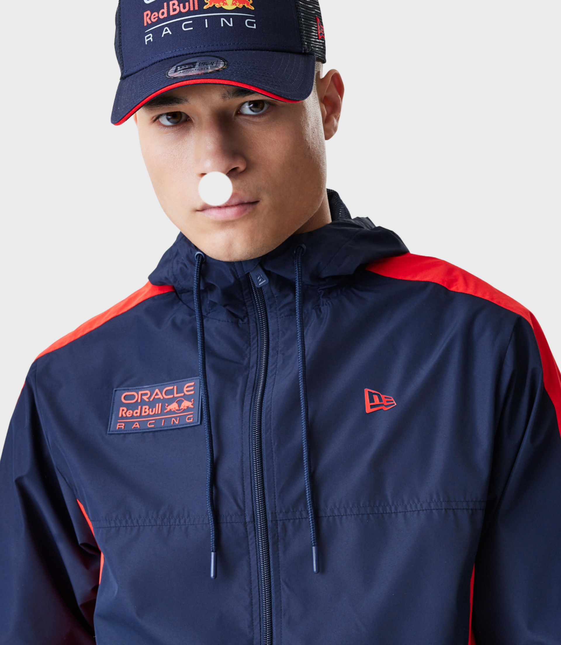 Close up of model wearing navy Red Bull Racing Windrunner jacket with orange piping and Oracle patch