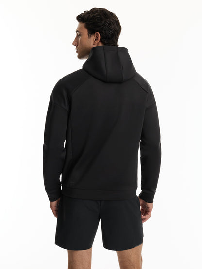 A man wearing a black hooded sweatshirt and matching black shorts, shown from the back against a plain white studio background.