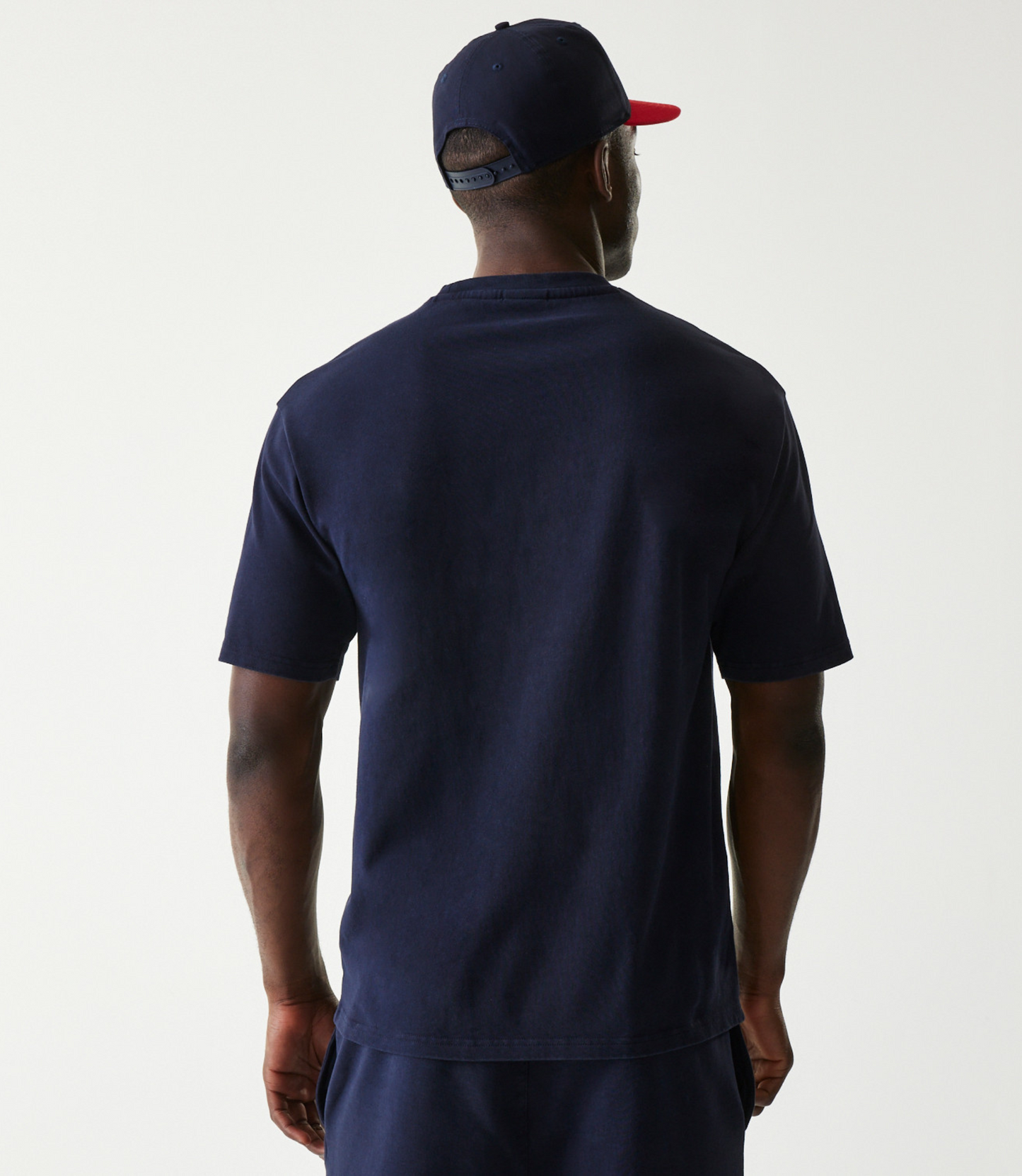 Back view of a man wearing a dark blue oversized Oracle Red Bull Racing T shirt