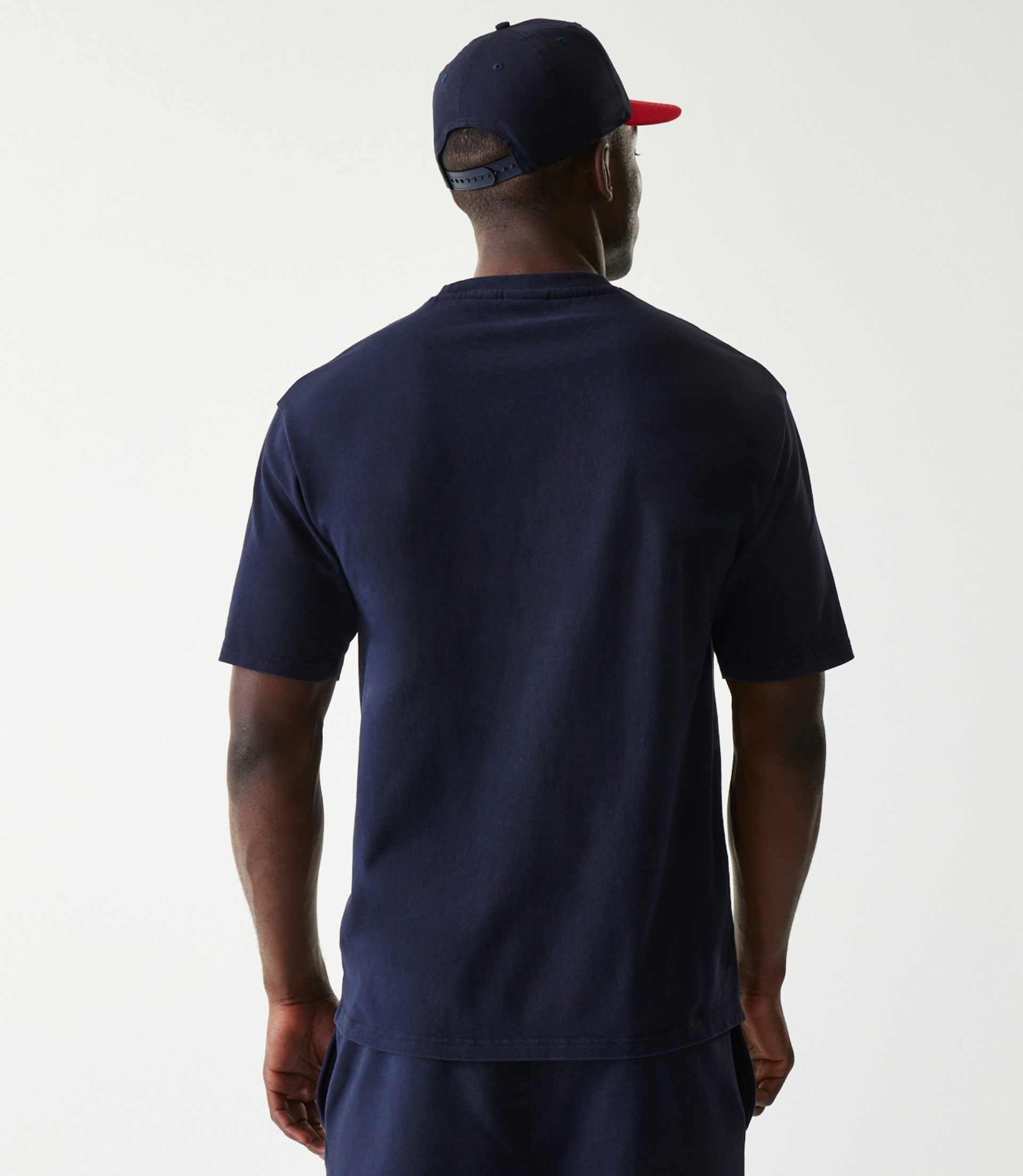 Back view of a man wearing a dark blue oversized Oracle Red Bull Racing T shirt