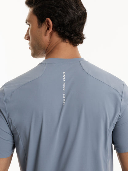 Rear view of a man wearing a light blue-gray athletic t-shirt with a vertical white 'REISS | CASTORE' logo printed on the back.