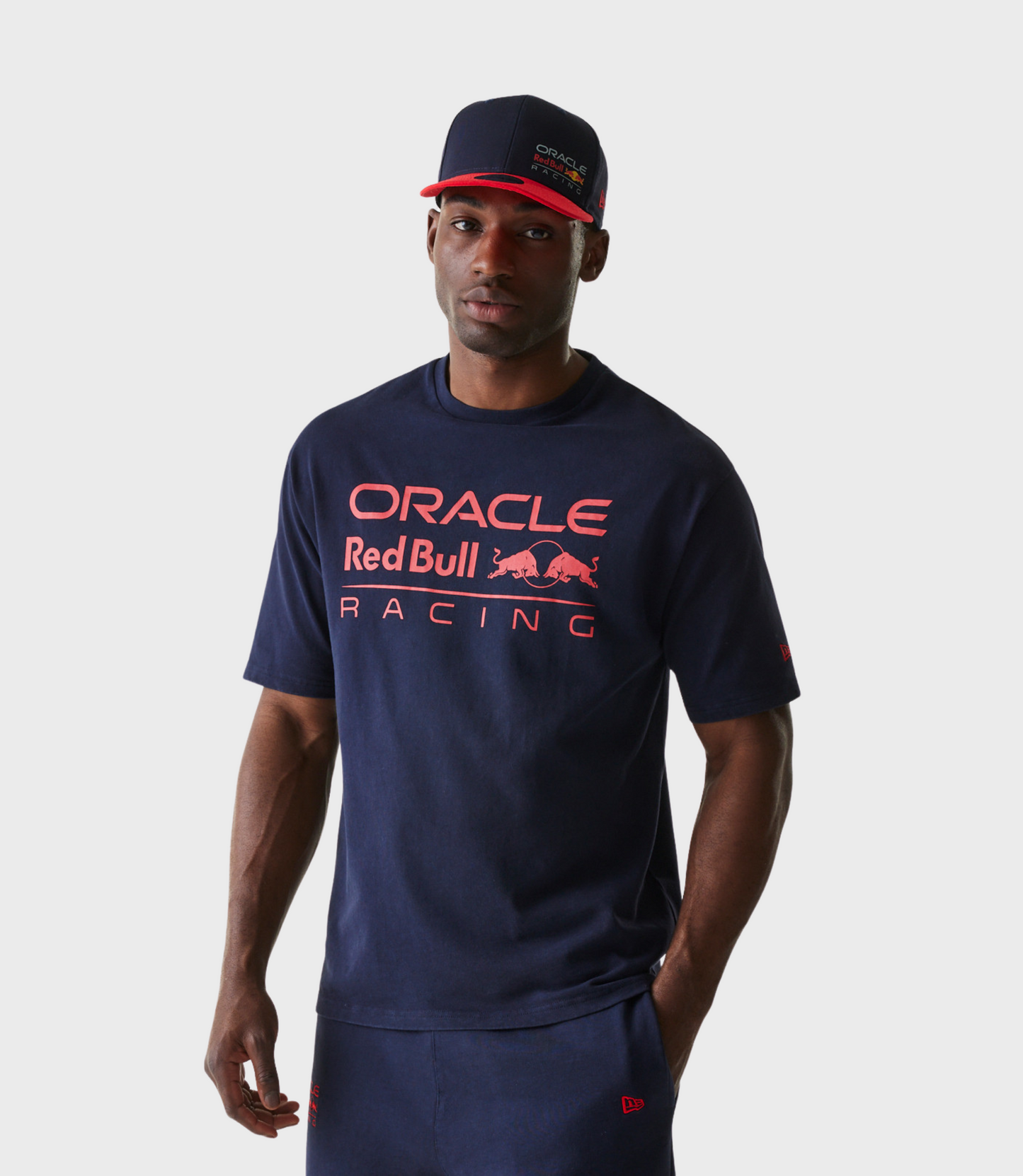 Male model wearing navy oversized Oracle Red Bull Racing T shirt and a navy cap with a red brim featuring Oracle Red Bull Racing branding.