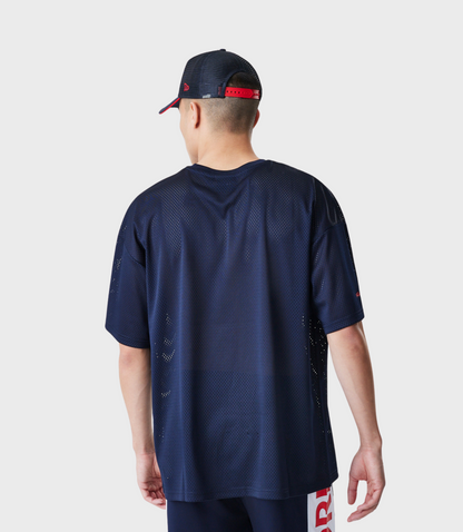 Back view of a model wearing navy mesh T shirt and matching shorts with red branding along the side seam.