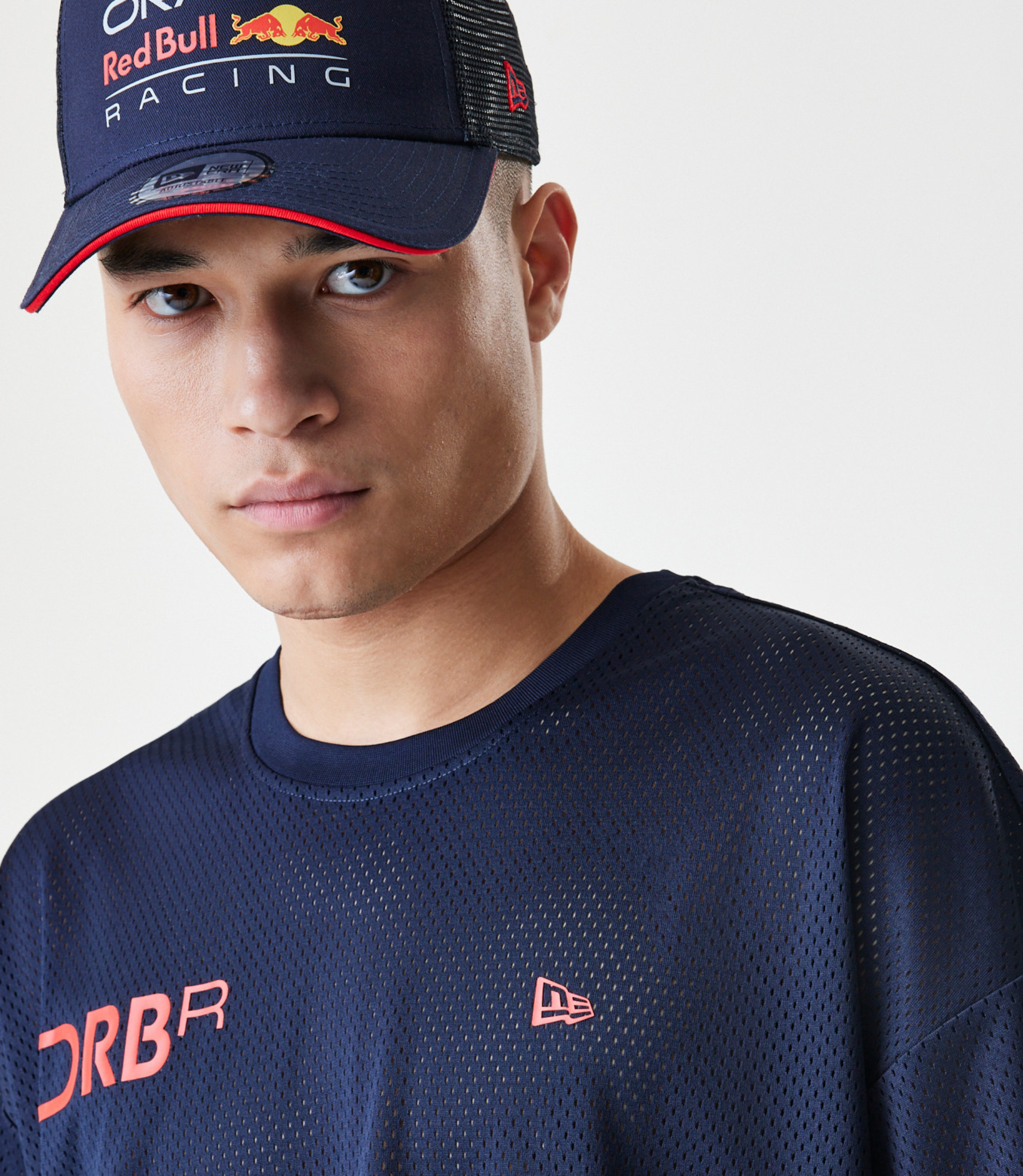 Front close up of a model wearing a dark blue mesh T shirt with pink Forever REBL lettering across the front.