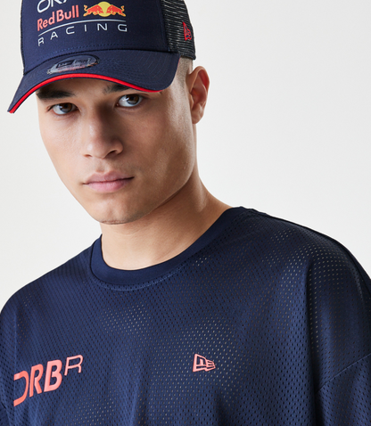 Front close up of a model wearing a dark blue mesh T shirt with pink Forever REBL lettering across the front.