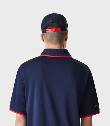Back view of a person wearing a navy mesh cap with a red adjustable strap and a matching navy top.