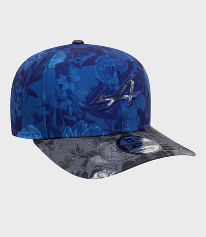 Close-up of navy floral cap crown with a black top button and a portion of the brim visible