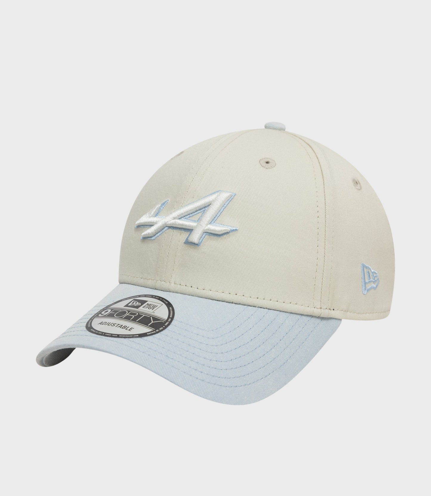 Beige cap with light blue top button, blue embroidery on the front and light blue under brim