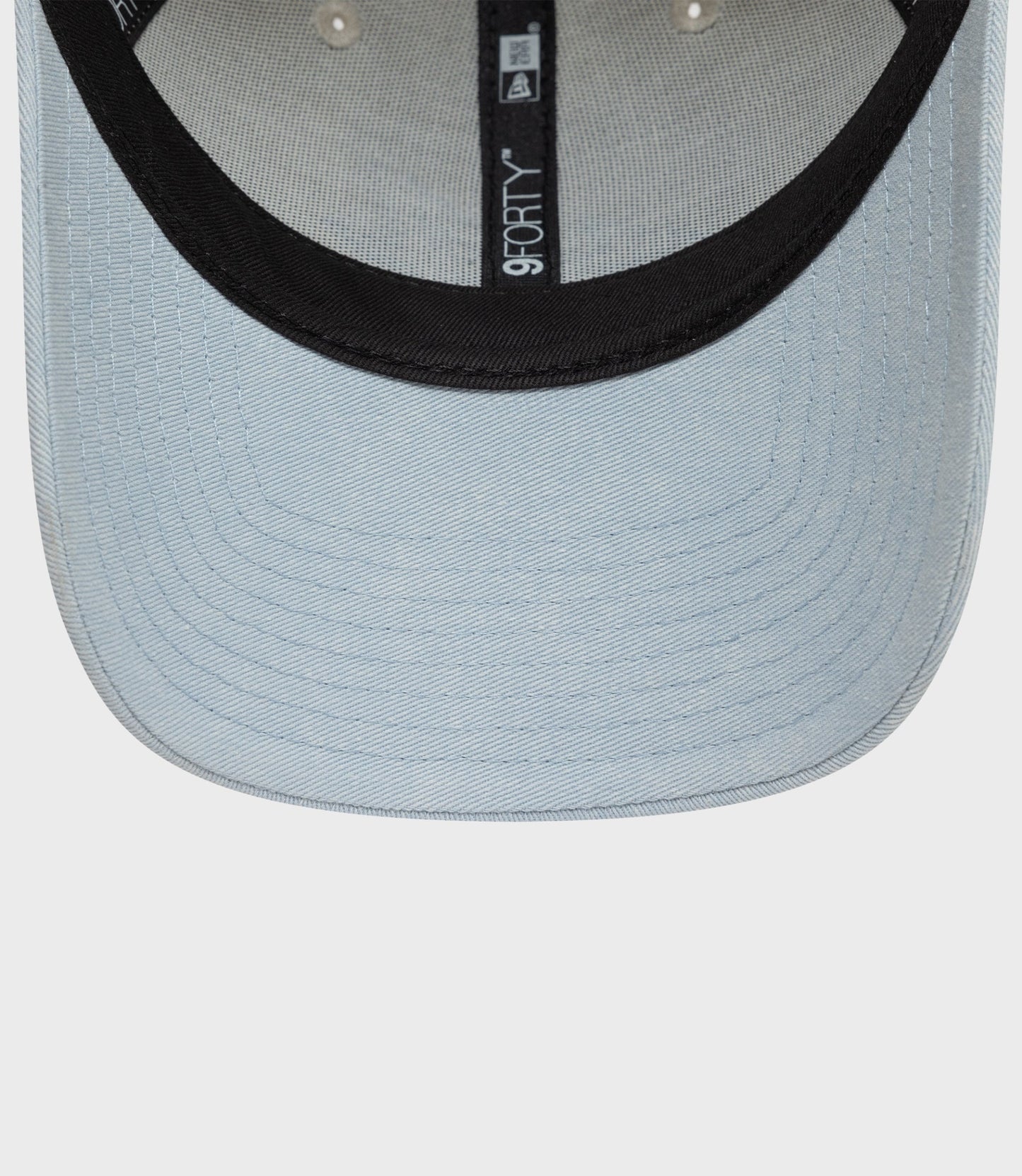 Creme Alpine Acid Wash 9Forty cap with light denim crown and black visor, featuring a vertical 9FORTY label.