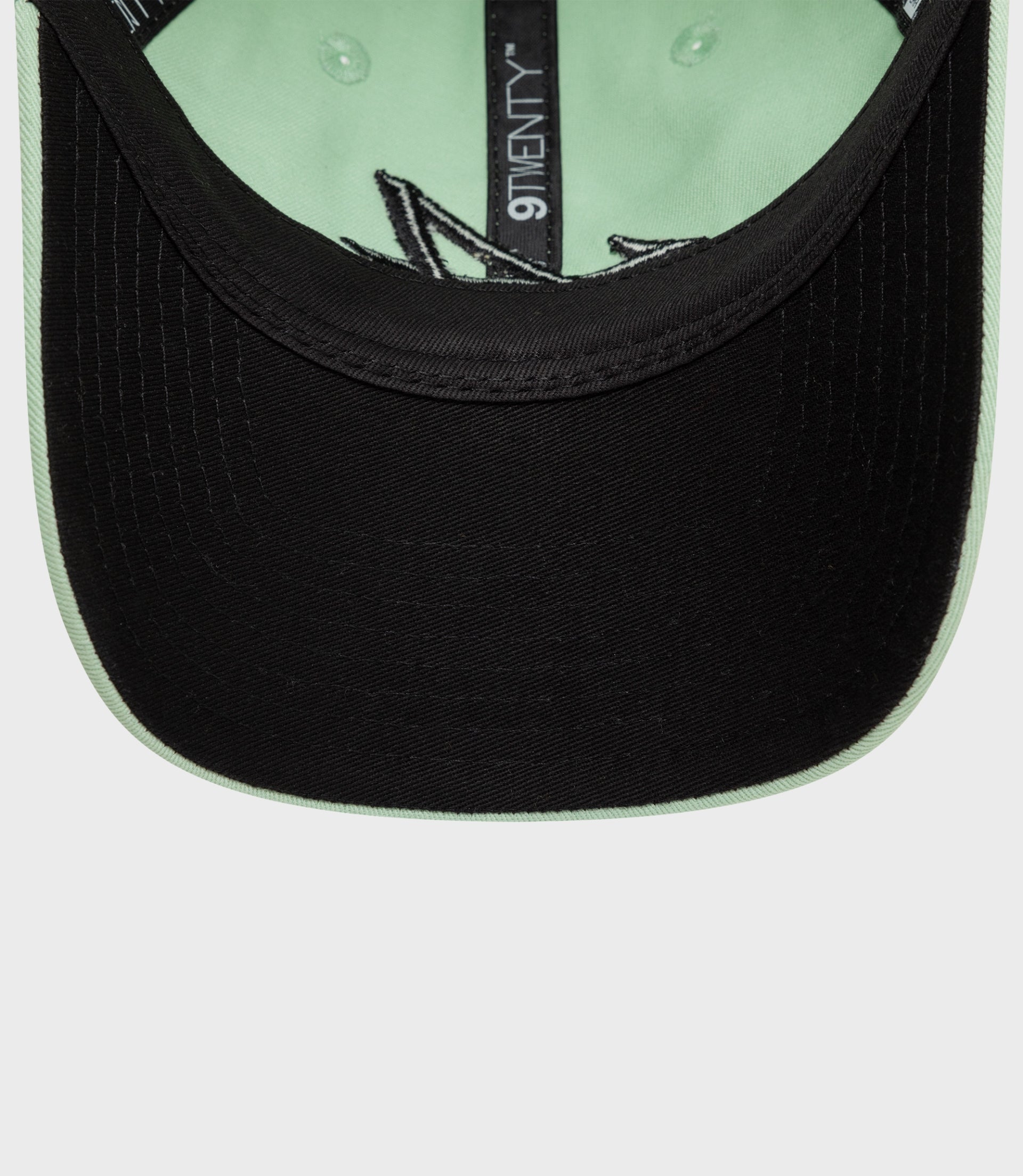 Rear view of mint green New Era 9Twenty cap with black underside of the brim and a metal buckle adjustable strap