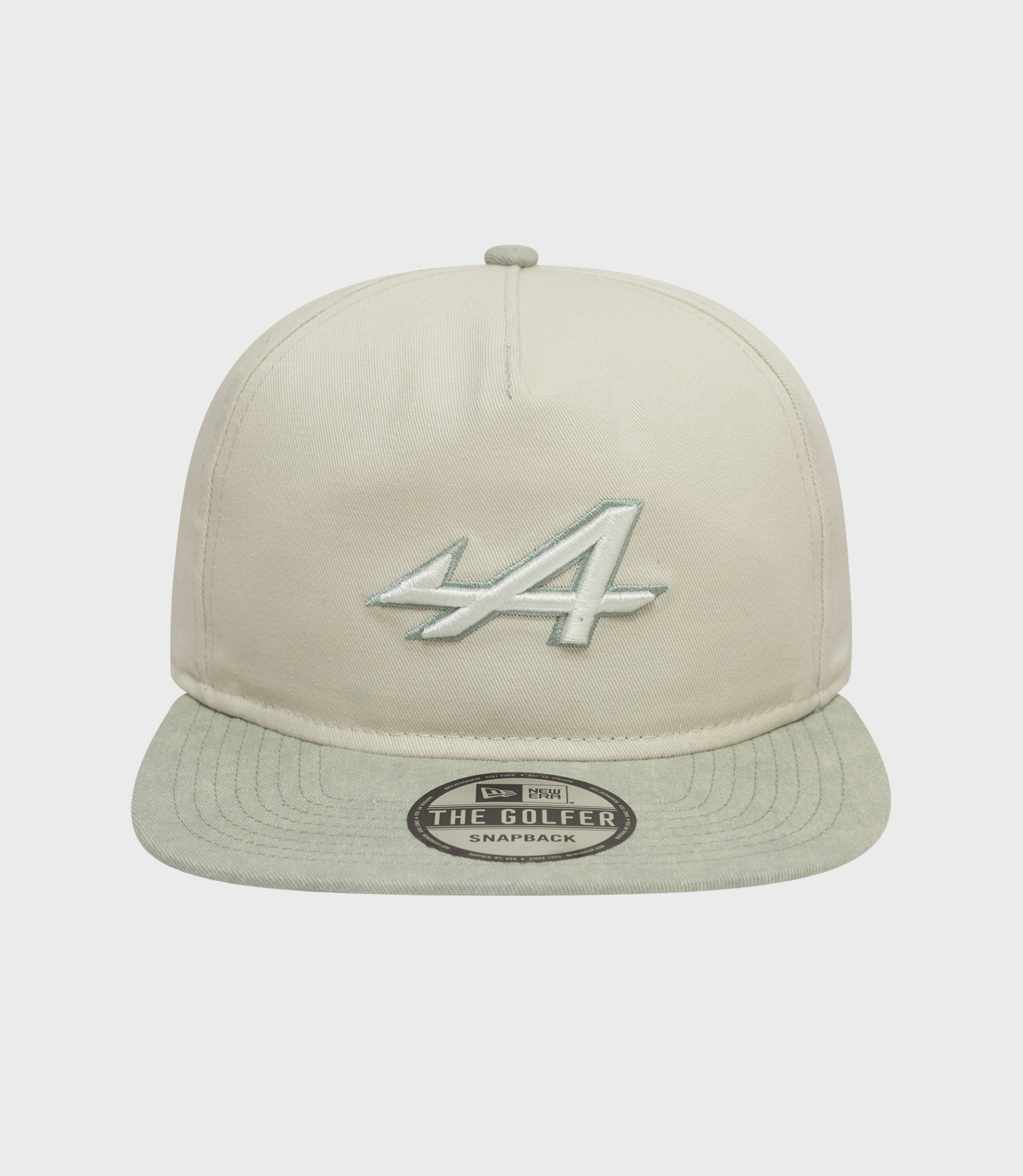 Angled shot of the Alpine Acid Wash Golfer Cap in white, highlighting crown stitching and the embroidered front logo.