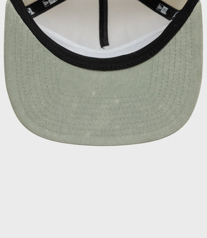 Close up of beige Alpine Acid Wash golfer cap showing black trim on the front brim.