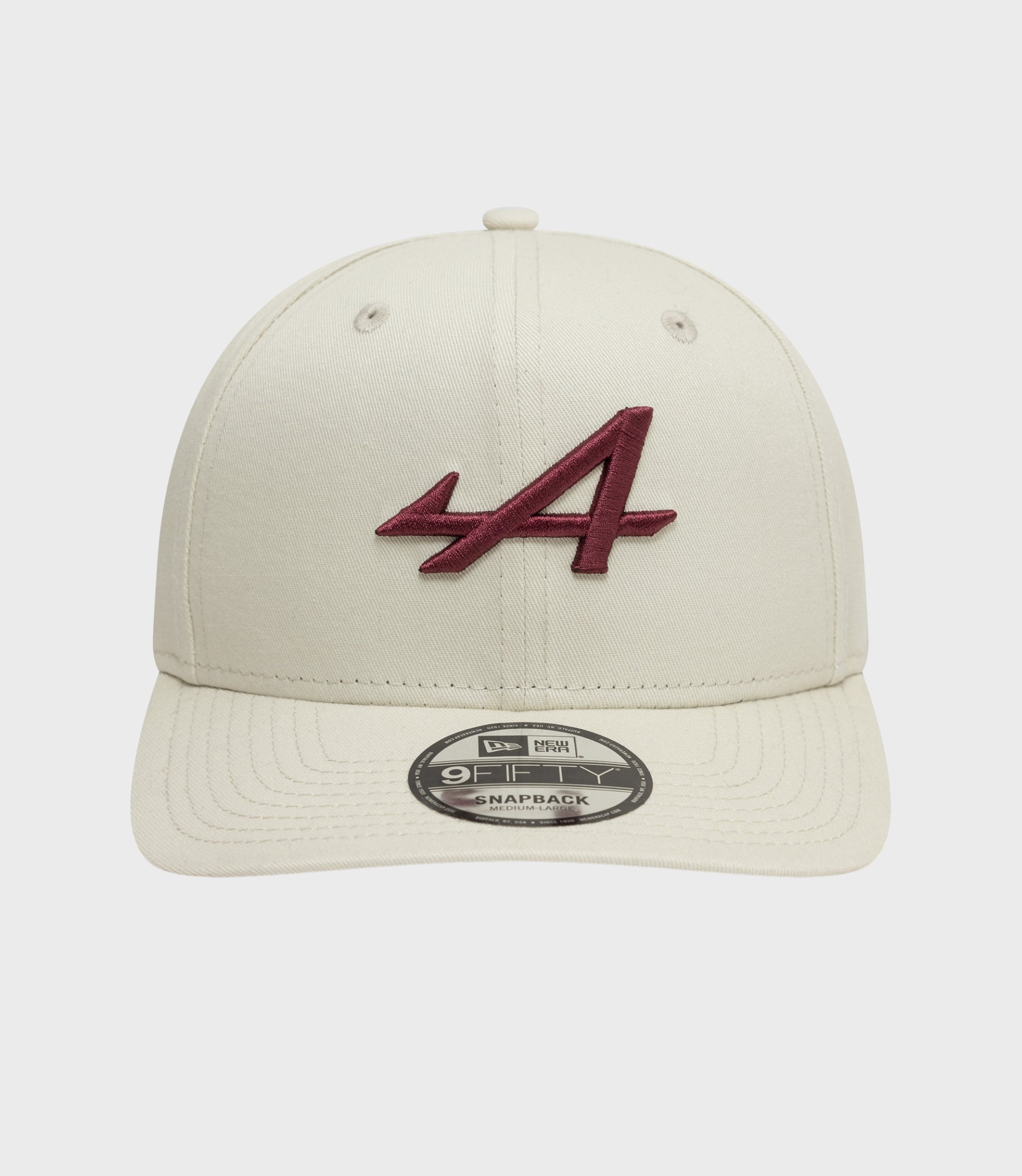 Cream New Era Alpine Seasonal 9Fifty Pre-Curve cap with burgundy embroidered logo on the front panel and a brim sticker.