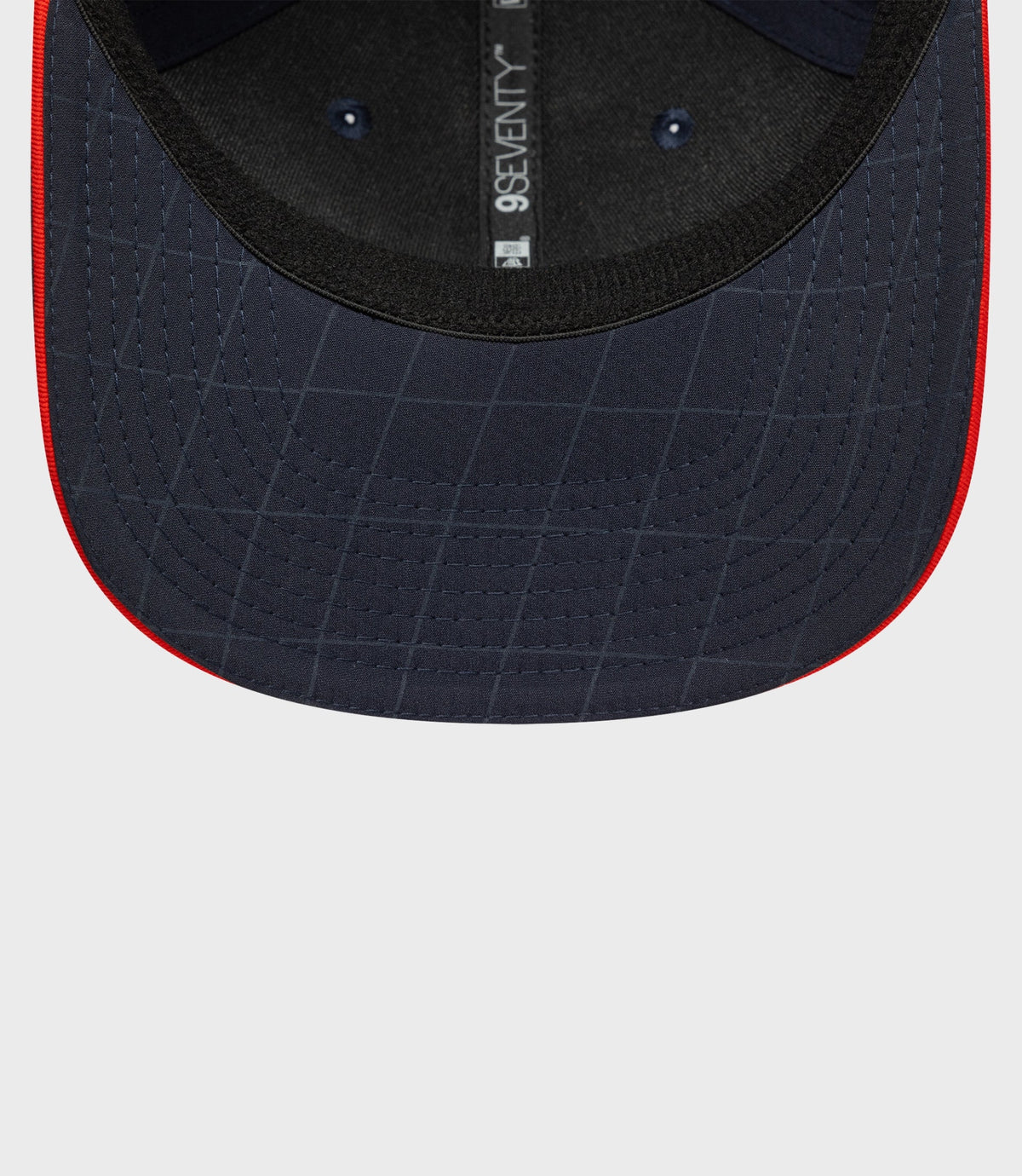 Back interior view of navy blue cap with adjustable strap and 9Seventy label along the back seam.