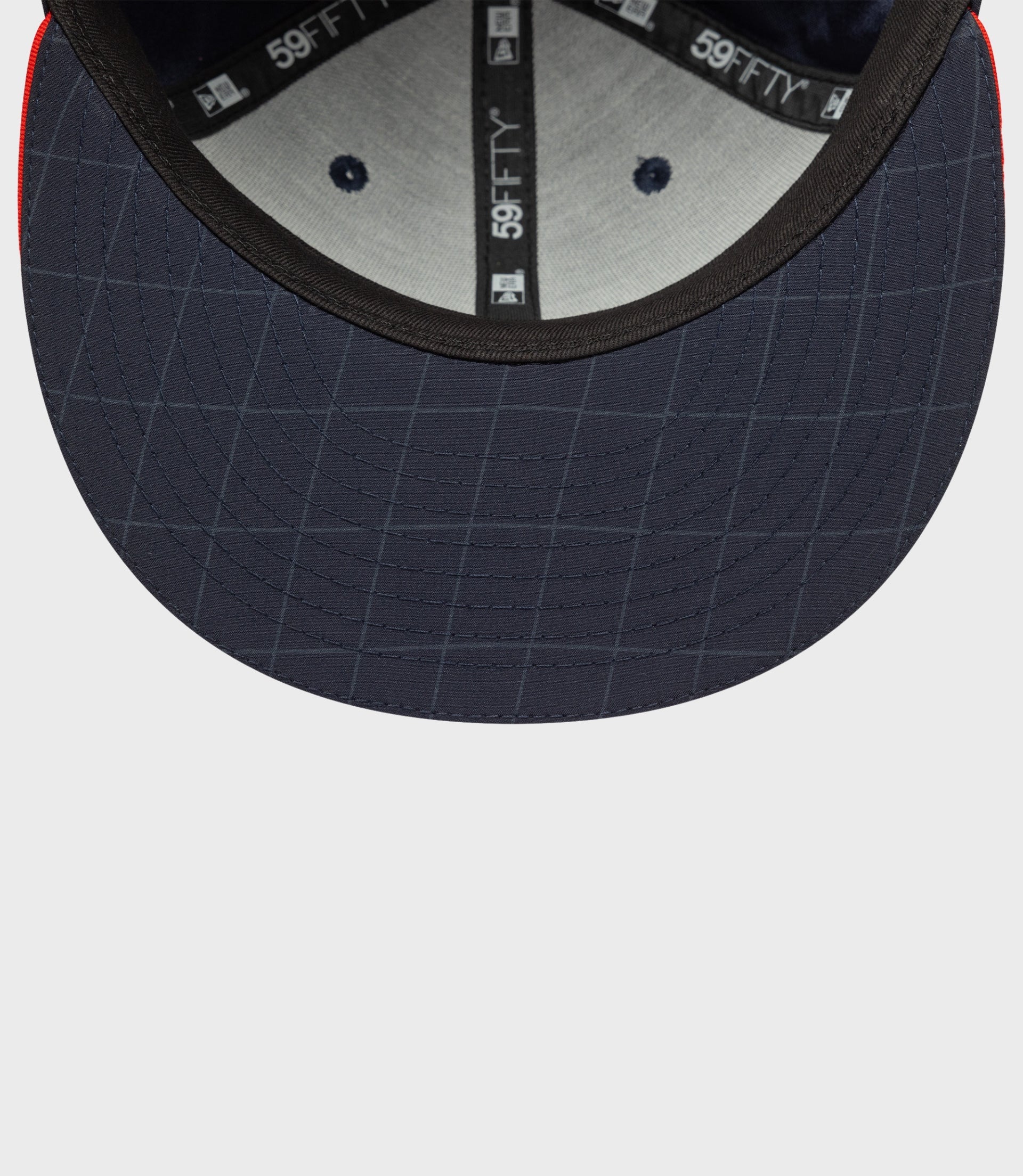 Interior view of navy blue 59FIFTY cap showing under brim stitching and inner branding tape.