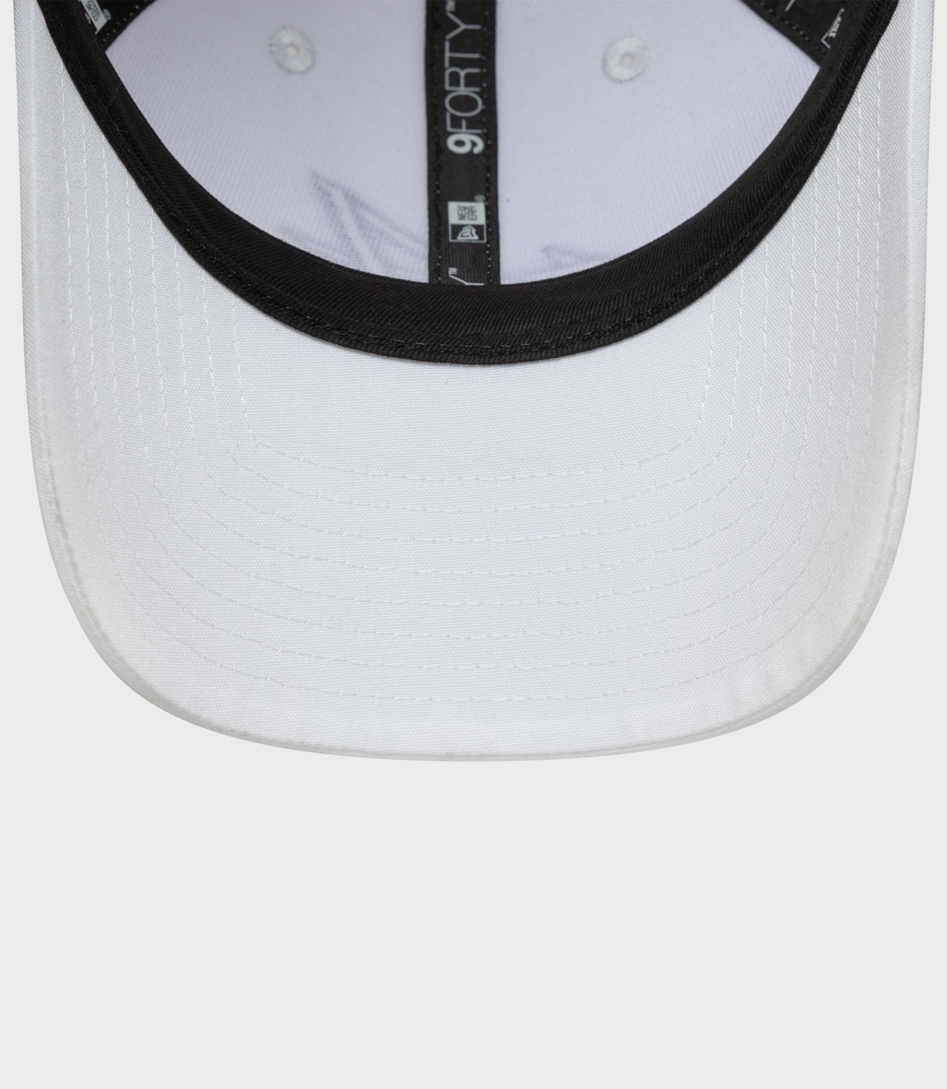 Close up of white New Era 9Forty cap brim with black trim and stitched detailing