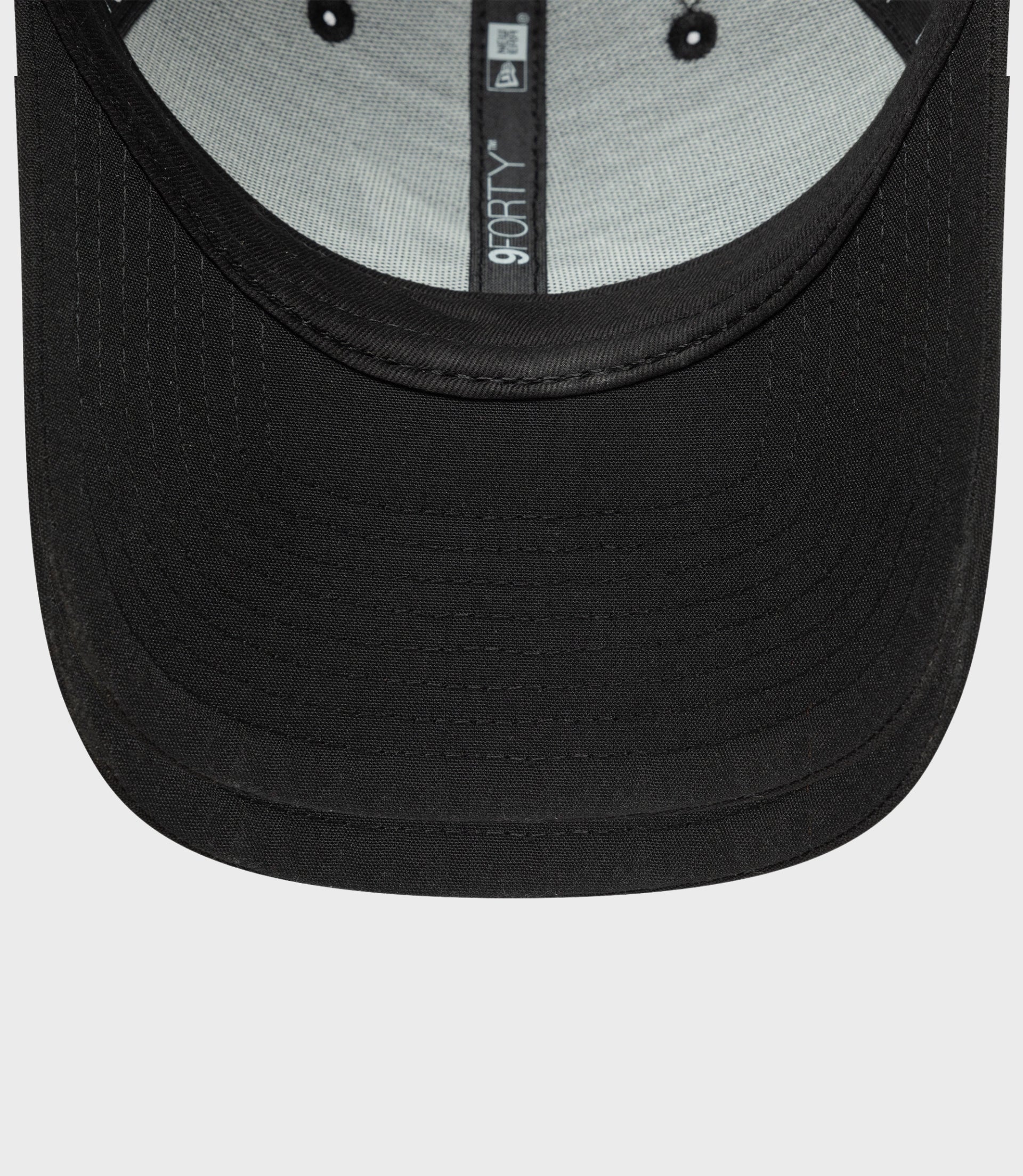 Close-up of black New Era Estretch Snapential 9Forty cap showing curved brim and inner 9FORTY label