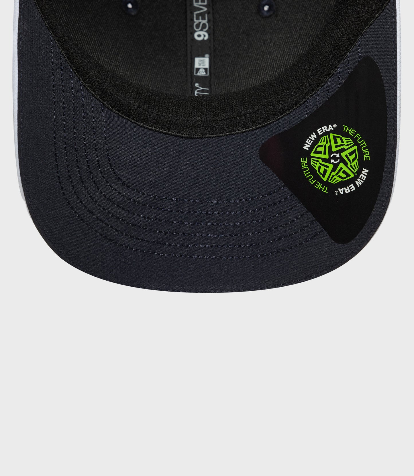 Front view of navy 9Seventy cap with a bright logo patch on the crown and pink piping along the brim