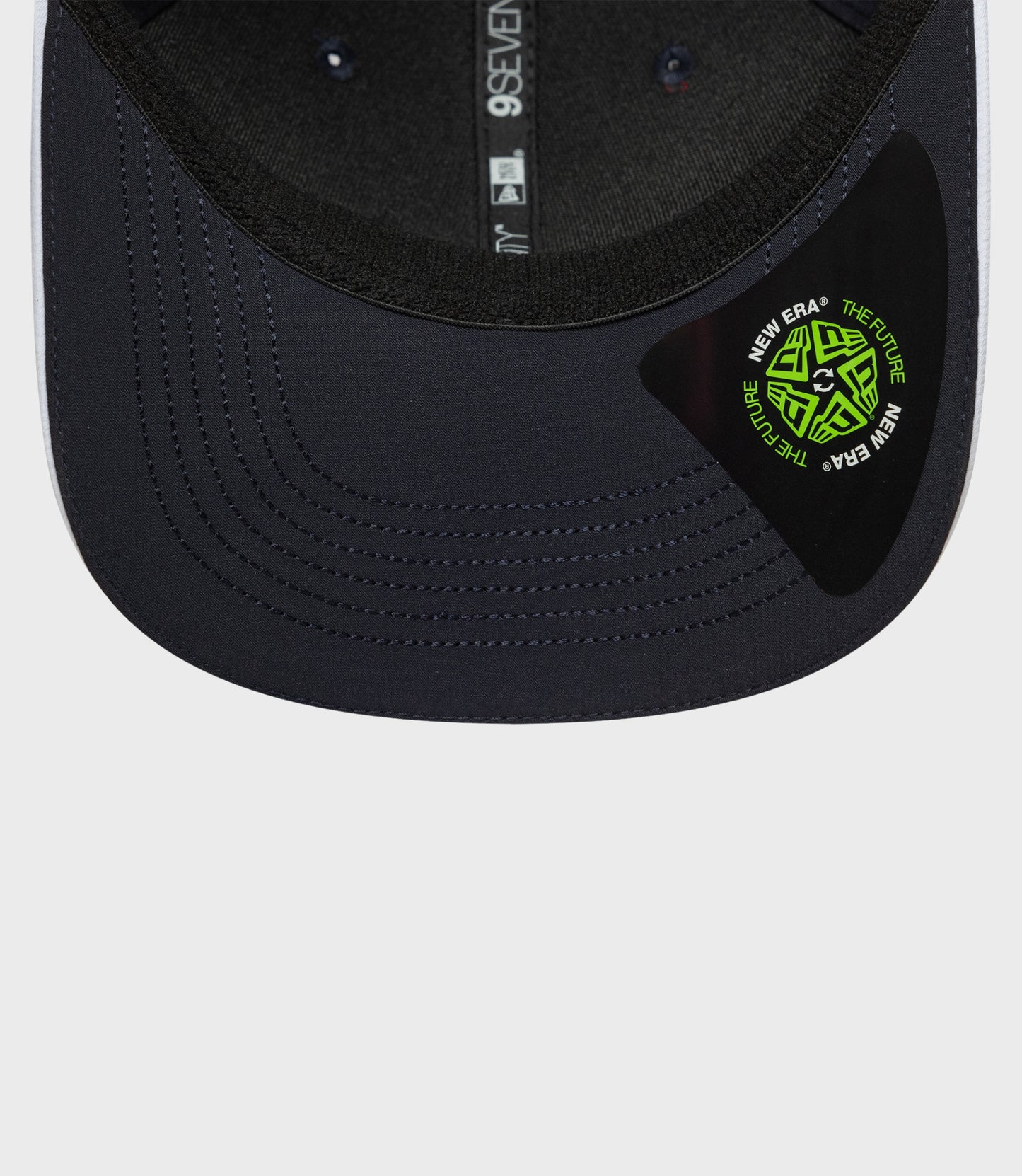 Navy New Era Rep Team 9Seventy stretch snap cap close up showing curved brim and stitched crown