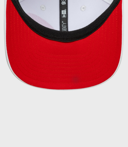 Close up of a red 9Seventy cap front panel with black edge trim and white interior, vertical tag visible