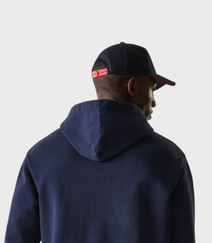 Profile view of a man wearing a navy blue oversized zip hoodie from New Era Oracle Red Bull Racing