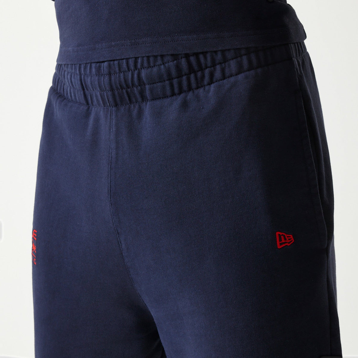 New Era flag embroidered on the left pocket of dark blue Oracle Red Bull Racing joggers.