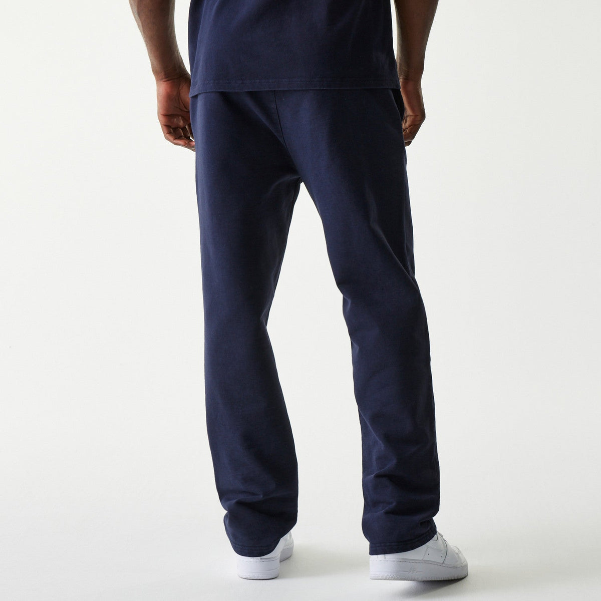 Navy Oracle Red Bull Racing joggers with New Era Flag left pocket and subtle branding, paired with white sneakers